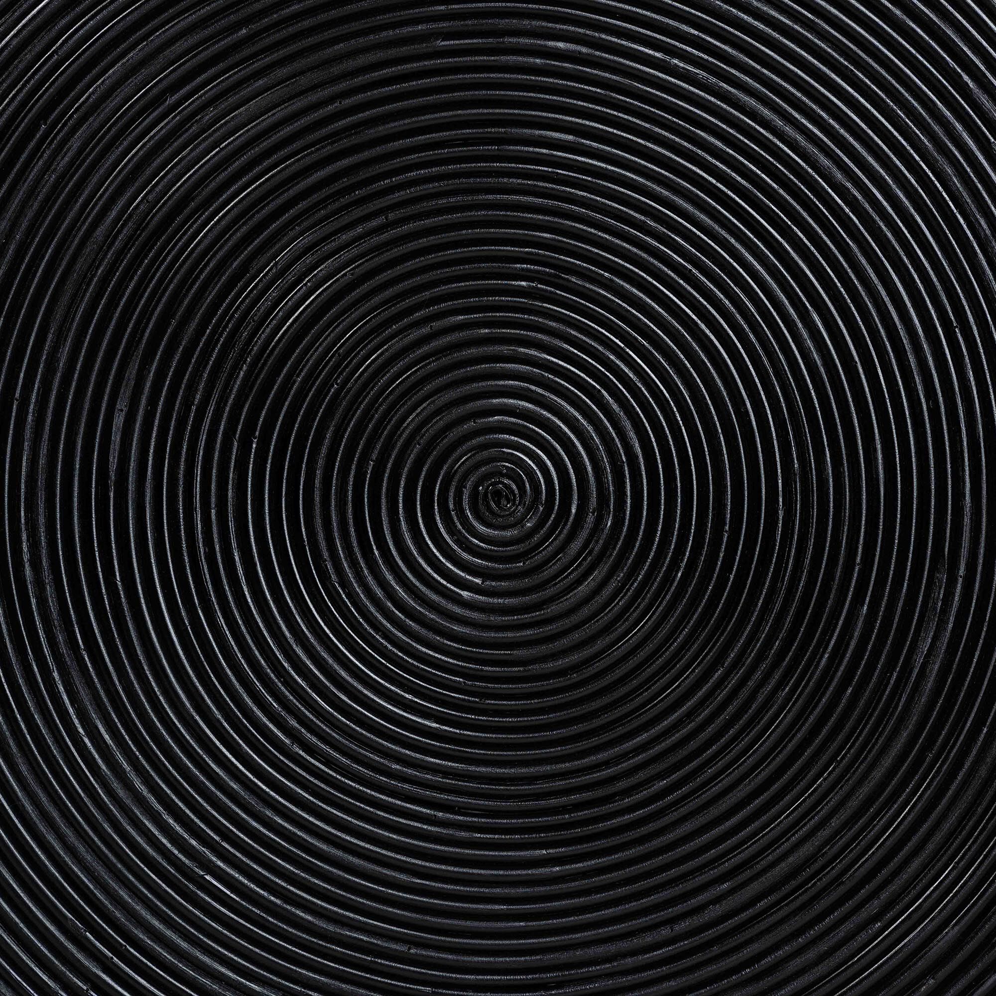 Close-up of black concentric laminated rattan rings on coffee table