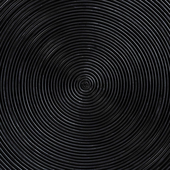 Close-up of black concentric laminated rattan rings on coffee table