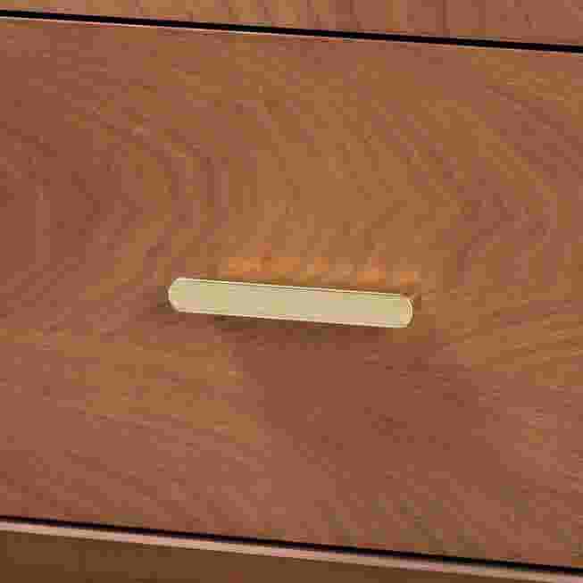 Close-up of a drawer handle on a wooden nightstand