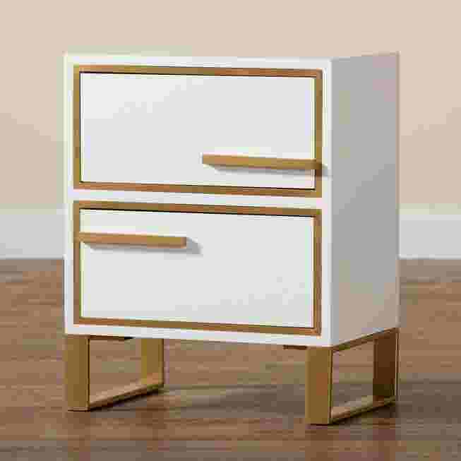 White nightstand with gold metal accents and two drawers on a wooden floor