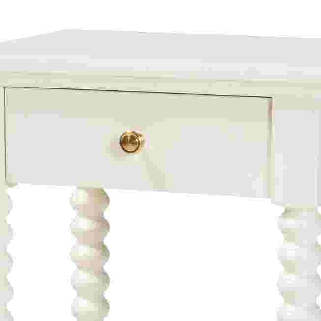 Close-up of the drawer and knob of a white nightstand.