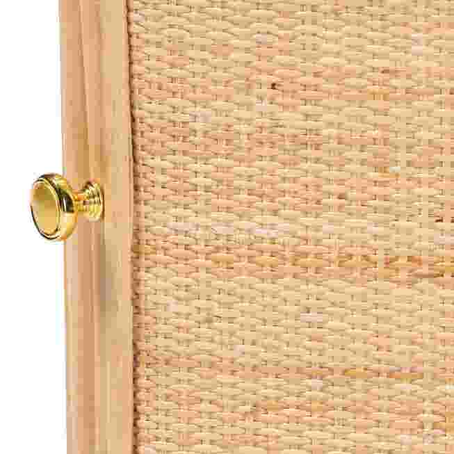 Close-up of a gold knob on a rattan nightstand door.