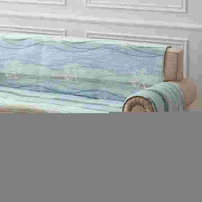 Close view of quilted sofa protector in light blue with brown arm trim