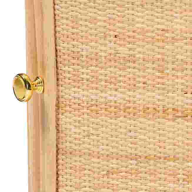 Close-up of a gold knob on a rattan nightstand door.