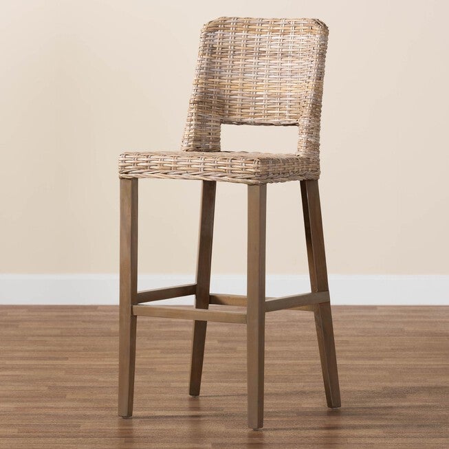 Grey rattan bar stool with mahogany frame in a room setting.