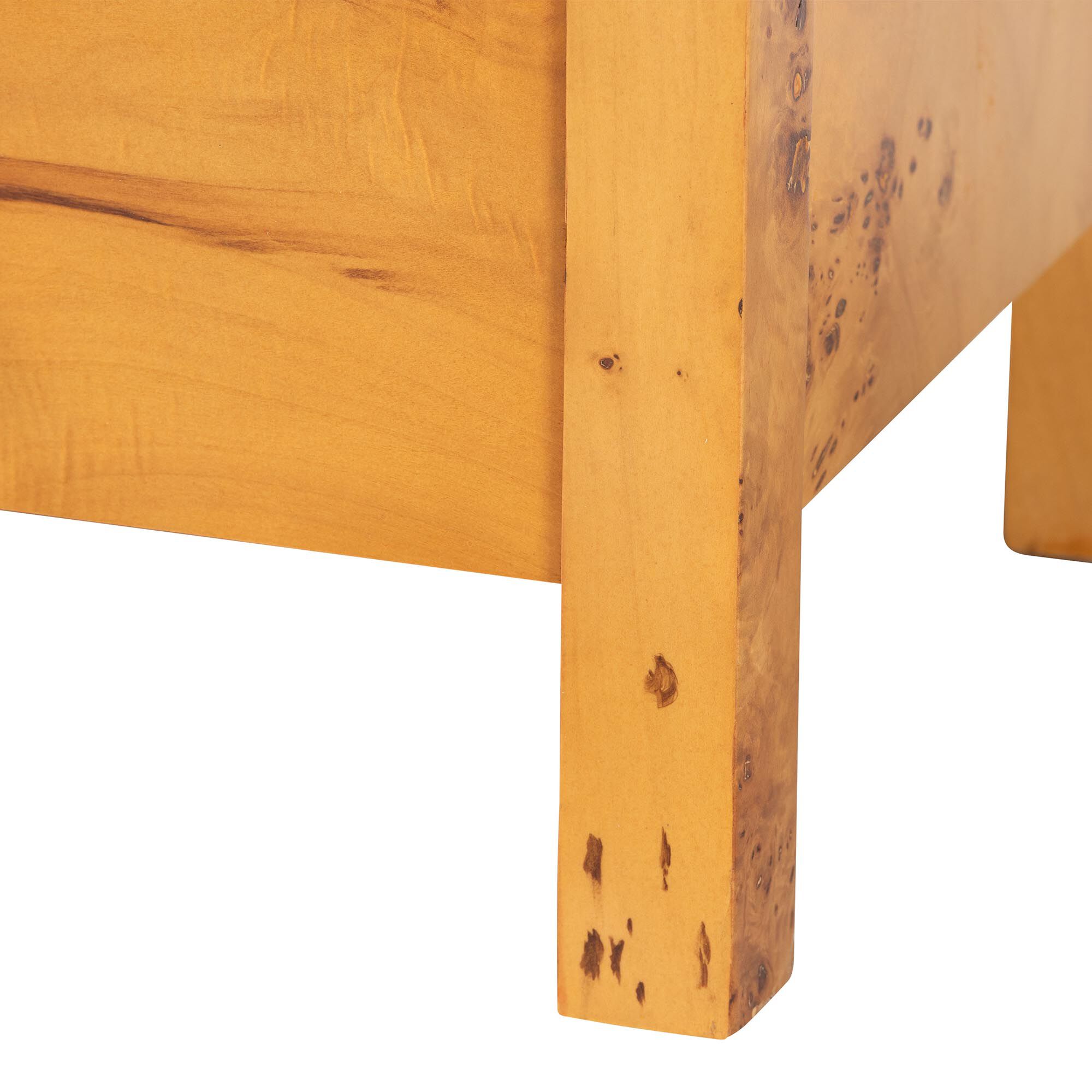 A close-up of the leg of a wooden nightstand, showing the wood grain and construction.