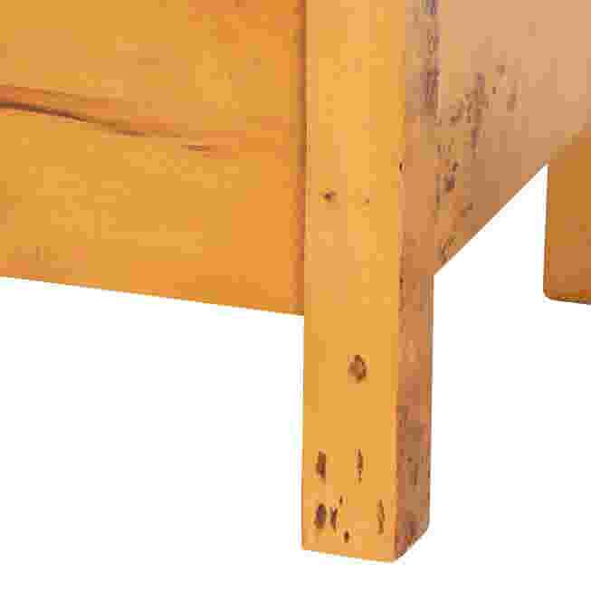 A close-up of the leg of a wooden nightstand, showing the wood grain and construction.