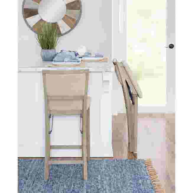 Grey wash folding bar stool with seat folded, in a kitchen setting
