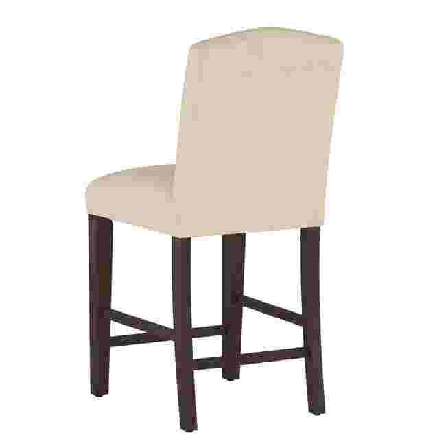 Velvet back counter stool with dark wooden legs and cream upholstery