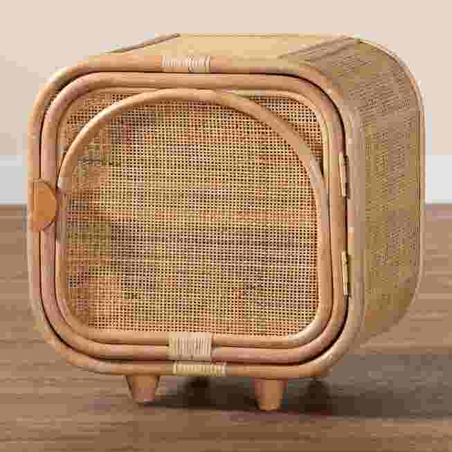 Rattan nightstand with a woven front, placed on a wooden floor.