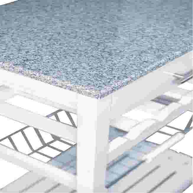 Corner view of white kitchen island granite top and storage openings