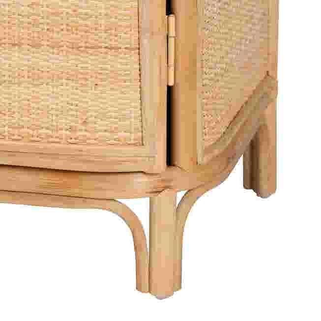 Close-up of the curved wooden legs of a rattan nightstand.