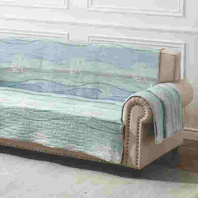 Quilted sofa protector arm section in light blue with brown/tan trim