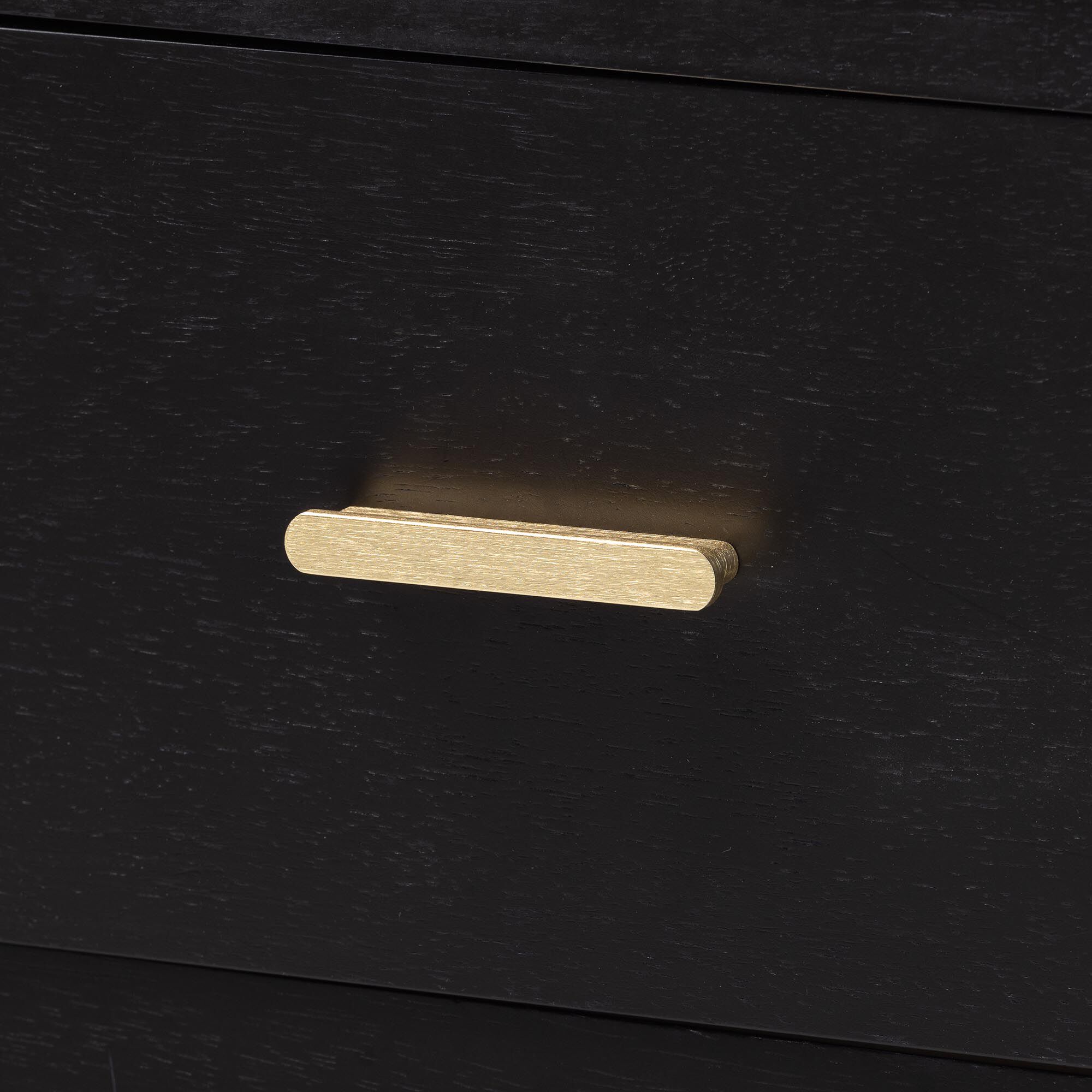 Close-up of gold bar pull on black Marisela nightstand drawer