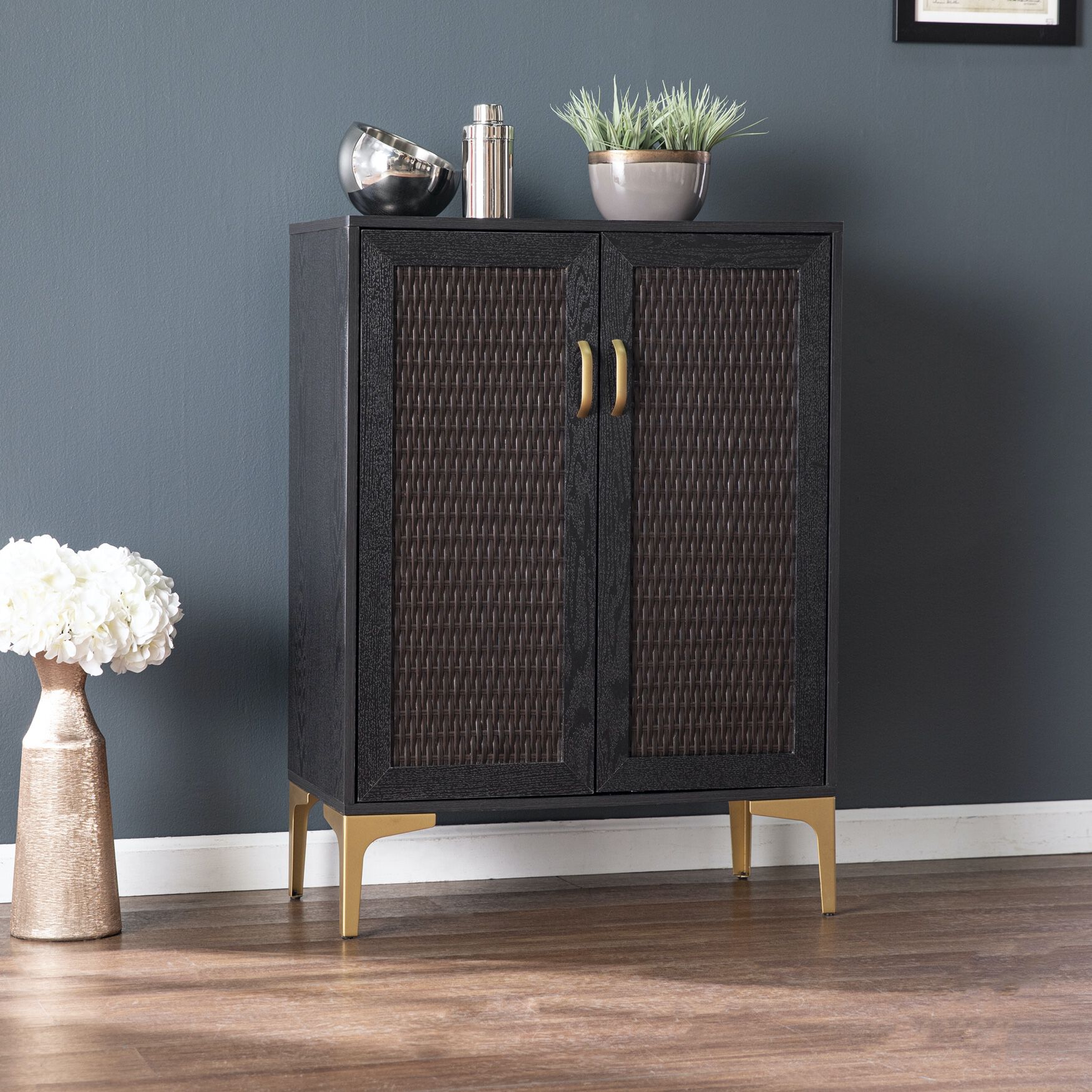 Side view of Rolliston two-door bar cabinet showing front with woven panels and gold legs