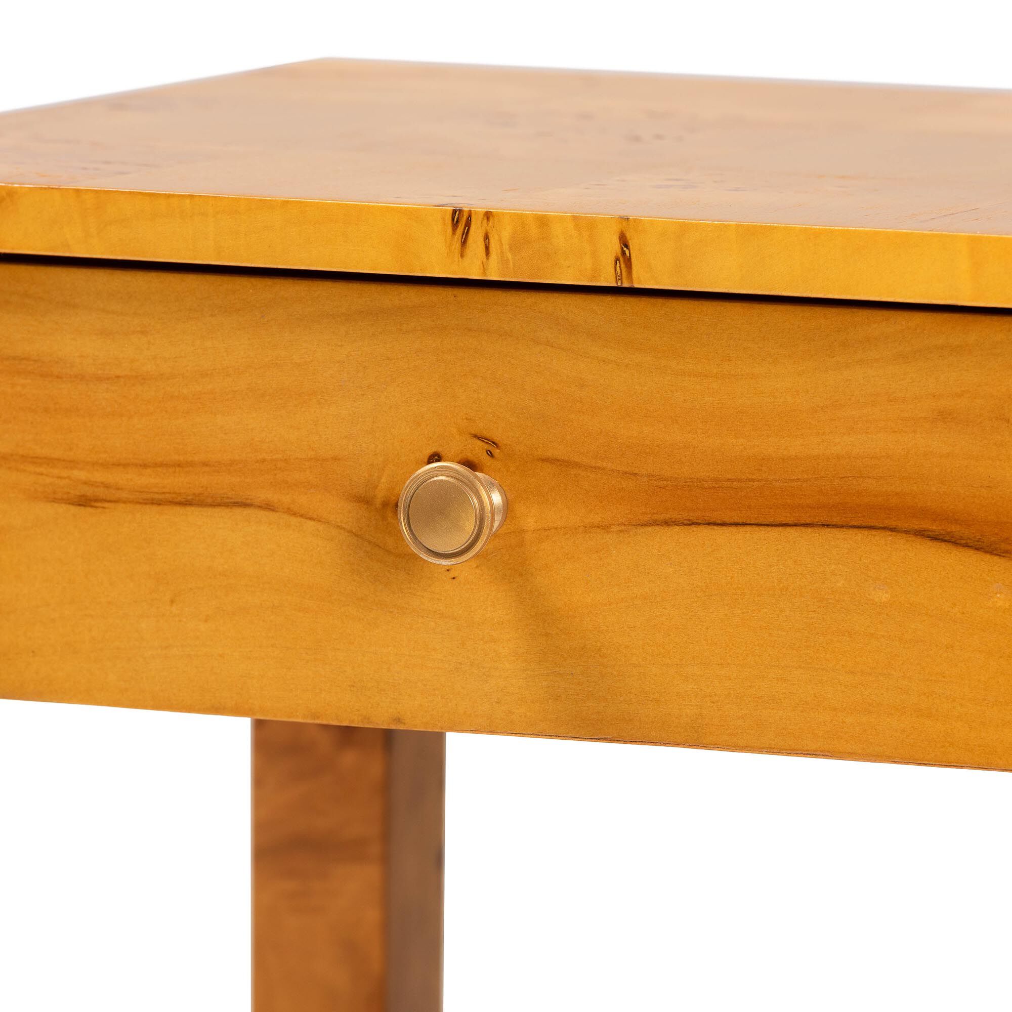 A close-up of a wooden drawer with a round knob on a nightstand.