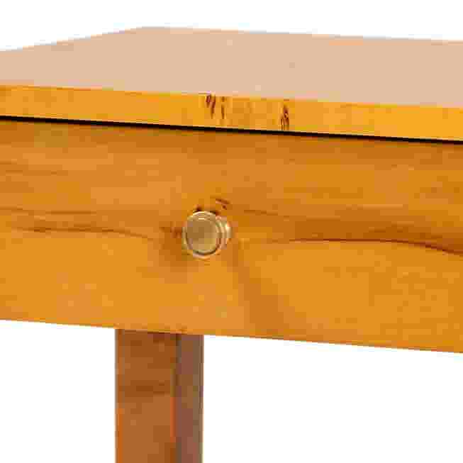 A close-up of a wooden drawer with a round knob on a nightstand.