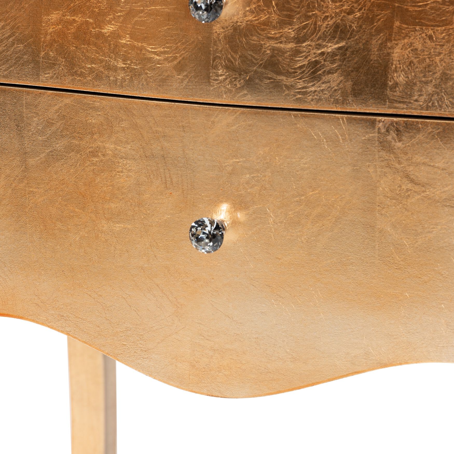 Close-up of drawer knob on gold nightstand