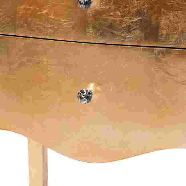 Close-up of drawer knob on gold nightstand
