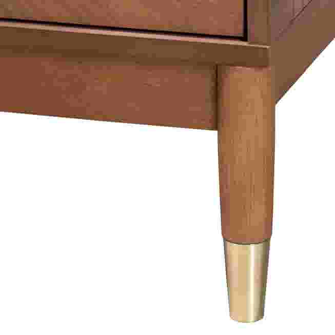 Close-up of a wooden leg with a metal foot on a nightstand