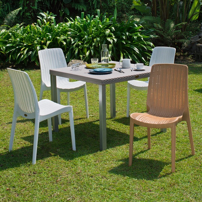 Outdoor dining set with four woven chairs around a table
