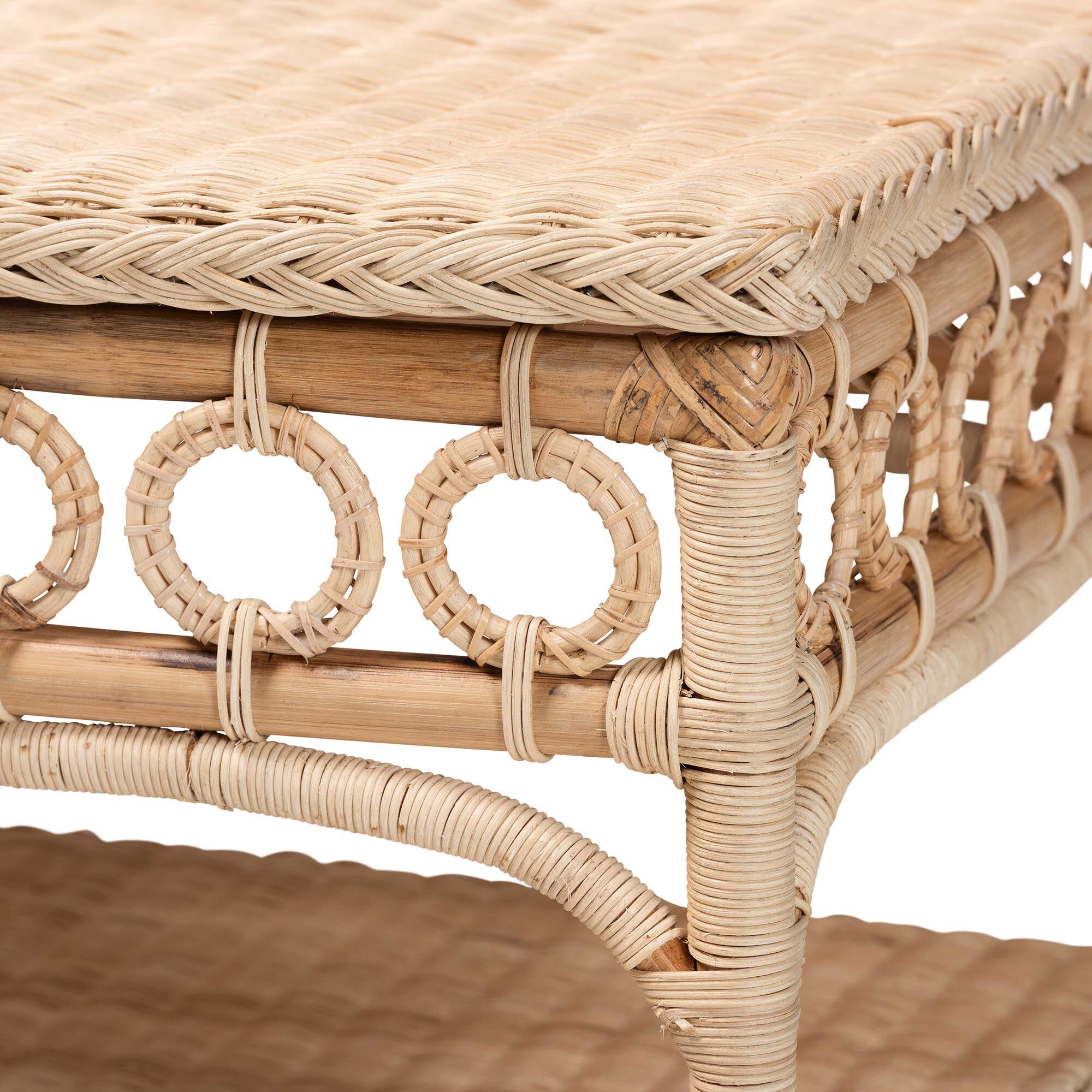Close-up of the rattan coffee table's side, showing the woven pattern and circular cutouts.