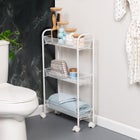 Three-tiered white rolling cart in bathroom